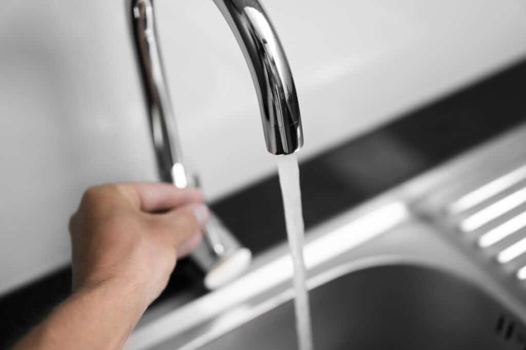 Cropped image of a man's hand closing the faucet