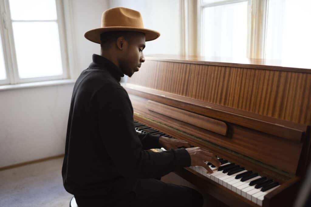 Medium shot of a man playing the piano in the room in the concept of 'How to Move Pianos and Other Large Fragile Objects When Moving House in Ealing'.