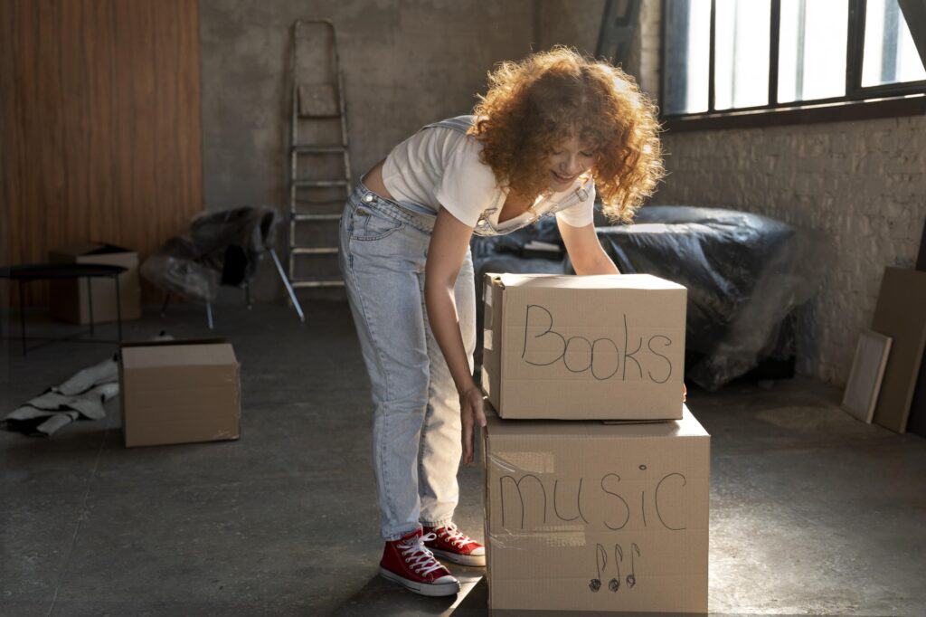 A woman about to lift clearly labelled boxes